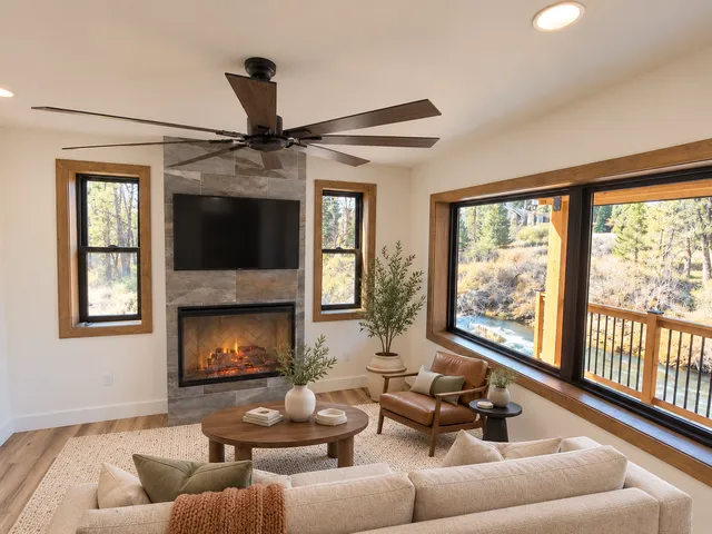 Living room fireplace, staged television and large river-facing window